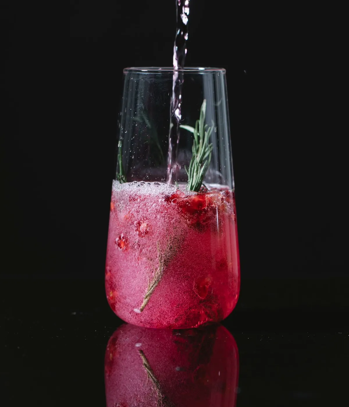 Cóctel con frutos rojos y una ramita de romero